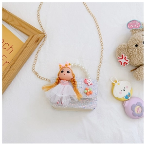 Detail of silver sequin crossbody bag with a 3D doll, lace dress, and pearl handle