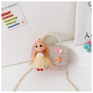 Detailed view of pink sequin girl bag with pearl handle and cartoon doll ornament