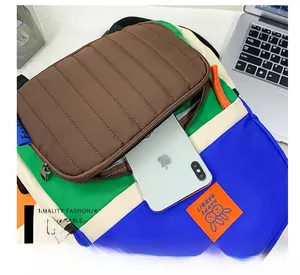 Practical front quilted pocket of color-block canvas backpack holding a smartphone