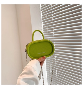 Detail of neon green mini bag with lychee texture and silver bead chain handle