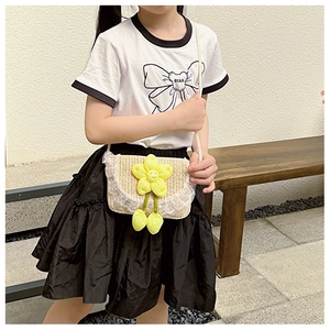 Detail of child straw crossbody bag with yellow flower charm and white lace trim edge