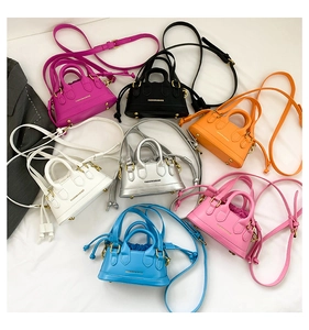 Detailed view of colorful mini handbags with dual handles and long shoulder straps