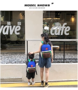 Outdoor shot of matching color-block canvas backpacks for parent and child in blue and green