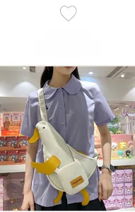 Vue détaillée d'un sac bandoulière canard blanc en toile avec ailes 3D sur mannequin