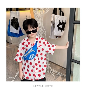 Detail of trendy kid shirt with red tomato prints and matching blue crossbody waist bag