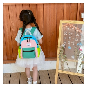 Vue détaillée du sac à dos enfant coloré avec design en patchwork rose et bleu