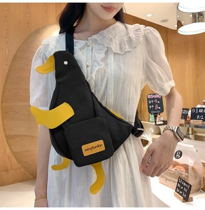 Détail du sac bandoulière créatif en toile canard noir avec pieds jaunes et poche avant