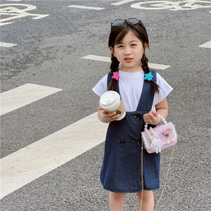 Girl wearing summer denim dress and pink sequin princess bag with pearl handle and rabbit charm