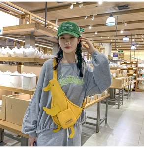 Détail d'un sac bandoulière canard jaune en toile avec bandoulière réglable et poche