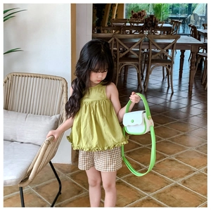 Détail d'un mini sac à main bicolore vert et blanc assorti à une tenue d'été pour fille