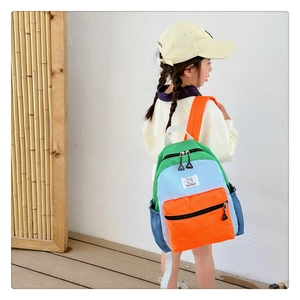 Détail du sac à dos coloré pour enfant avec poches latérales porté par une fille