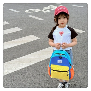 Fillette portant un sac à dos scolaire coloré en toile avec design contrasté en extérieur