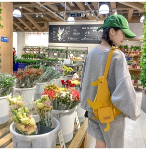 Sac bandoulière mignon en toile en forme de canard jaune dans un magasin de fleurs