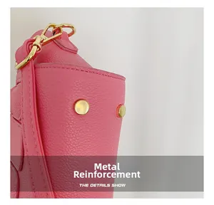 Close-up of pink litchi grain leather bag with reinforced gold metal hardware details