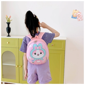 Pink toddler backpack with cartoon rabbit shell shown in a warm home lifestyle setting