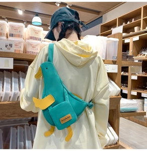 Détail d'un sac bandoulière canard en toile verte avec une petite poche latérale carrée