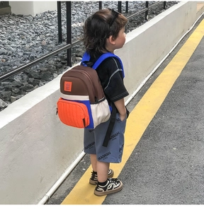 Detail of color-block canvas kids backpack featuring Happy Rabbit patch on the front pocket