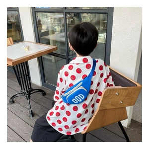 Detail of blue nylon kid chest bag with white DOD letters and dual zipper closure
