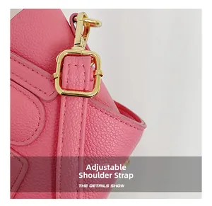 Macro detail of pink litchi leather bag showing adjustable strap and gold metal buckle