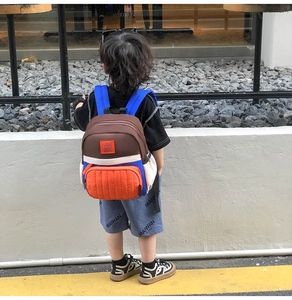 Kids color-block canvas backpack with orange rabbit embroidery shown on child back