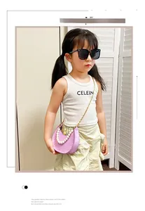 Detail of purple crocodile pattern kids bag with pearl handle and metal chain strap