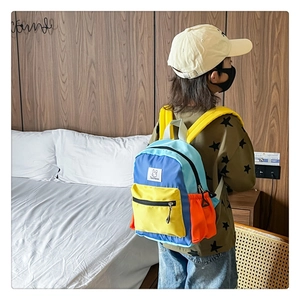 Détail d'un sac à dos color-block pour enfant en nylon bleu et jaune avec bretelles ajustables