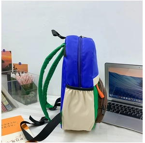 Detail view of colorful patchwork backpack with side pockets and padded green straps