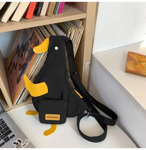 Détail d'un sac bandoulière canard noir en toile avec bec jaune et pieds décoratifs en 3D