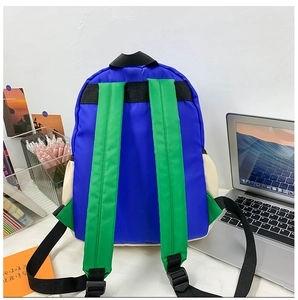 Detail of color-block backpack showing contrast navy and green straps with nylon texture