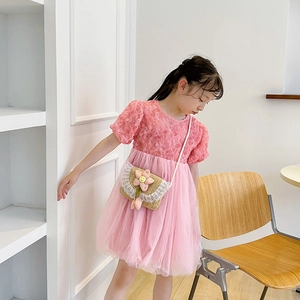 Girl's pink dress with floral textures and a cute woven sunflower mini crossbody bag
