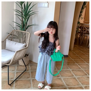 Detail of girls floral tiered top and wide-leg jeans with green mini basket bag