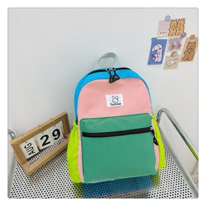 Détail du sac à dos coloré pour enfants avec écusson logo et plusieurs fermetures