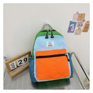 Détail du sac à dos enfant color-block avec étiquette lapin Tochaso et poche avant