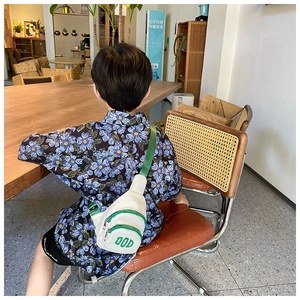 Rear view of child wearing a white and green chest bag with DOD letter printing