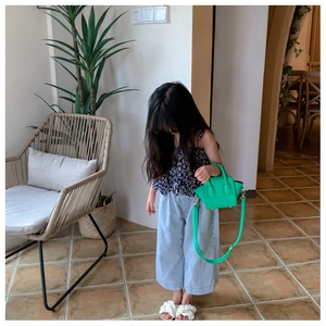 Close-up of vibrant green mini luggage style handbag for girls with crossbody strap