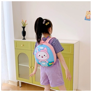 Pink toddler backpack with cartoon cat shell design shown on a child near a locker