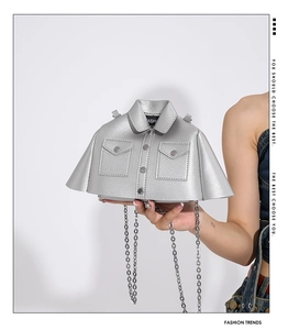Detail of silver jacket-shaped creative handbag with metallic PU texture and chain strap