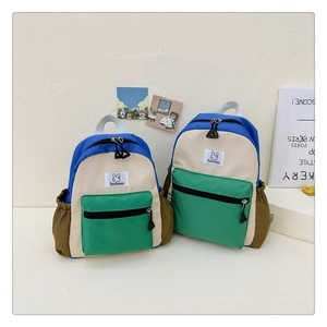 Détail d'un sac à dos enfant en toile color-block avec étiquette lapin et finitions