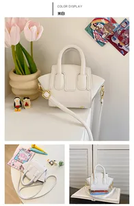 Detail of a creamy white trapeze bag for girls with high-quality litchi grain leather