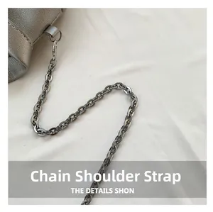 Detail of silver chain strap with metal swivel hook on textured leather shoulder bag