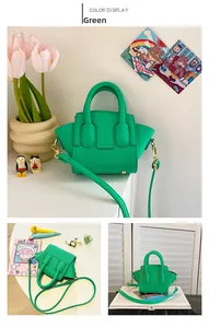Close-up of green lychee leather mini handbag with gold hardware and shoulder strap