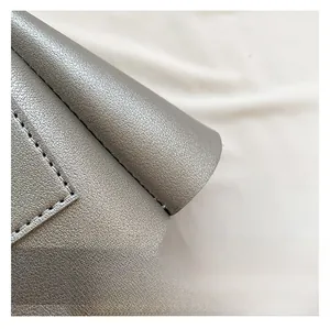 Close-up of silver-gray PU leather texture with detailed stitching and grain