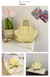 Detail view of yellow mini crossbody bag with litchi texture and round handles