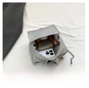 Silver chain shoulder bag showing internal capacity for phone, notebook and cosmetics