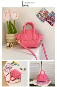 Detailed view of a pink mini wing bag with litchi grain texture and gold hardware