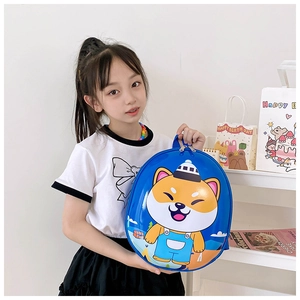 Blue kids backpack with cartoon dog pattern held by a child against white wall