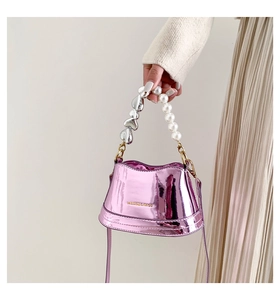 Detail of fashion mini bag with pearl and silver heart handle on metallic pink leather