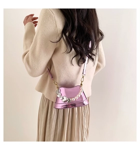 Dettaglio mini borsa rosa metallizzato con perle e catena a forma di cuore decorativa