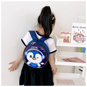 Close-up of a blue cartoon penguin hardshell backpack worn by a toddler child