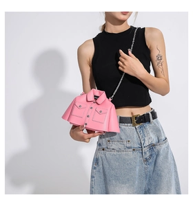 Pink moto jacket shaped creative crossbody bag with silver chain strap on a model